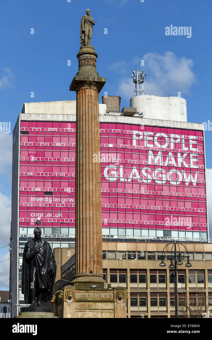 Scott Monument su George Square Glasgow nel centro della città, Scozia, Regno Unito con la gente fare segno Glasgow sullo sfondo Foto Stock