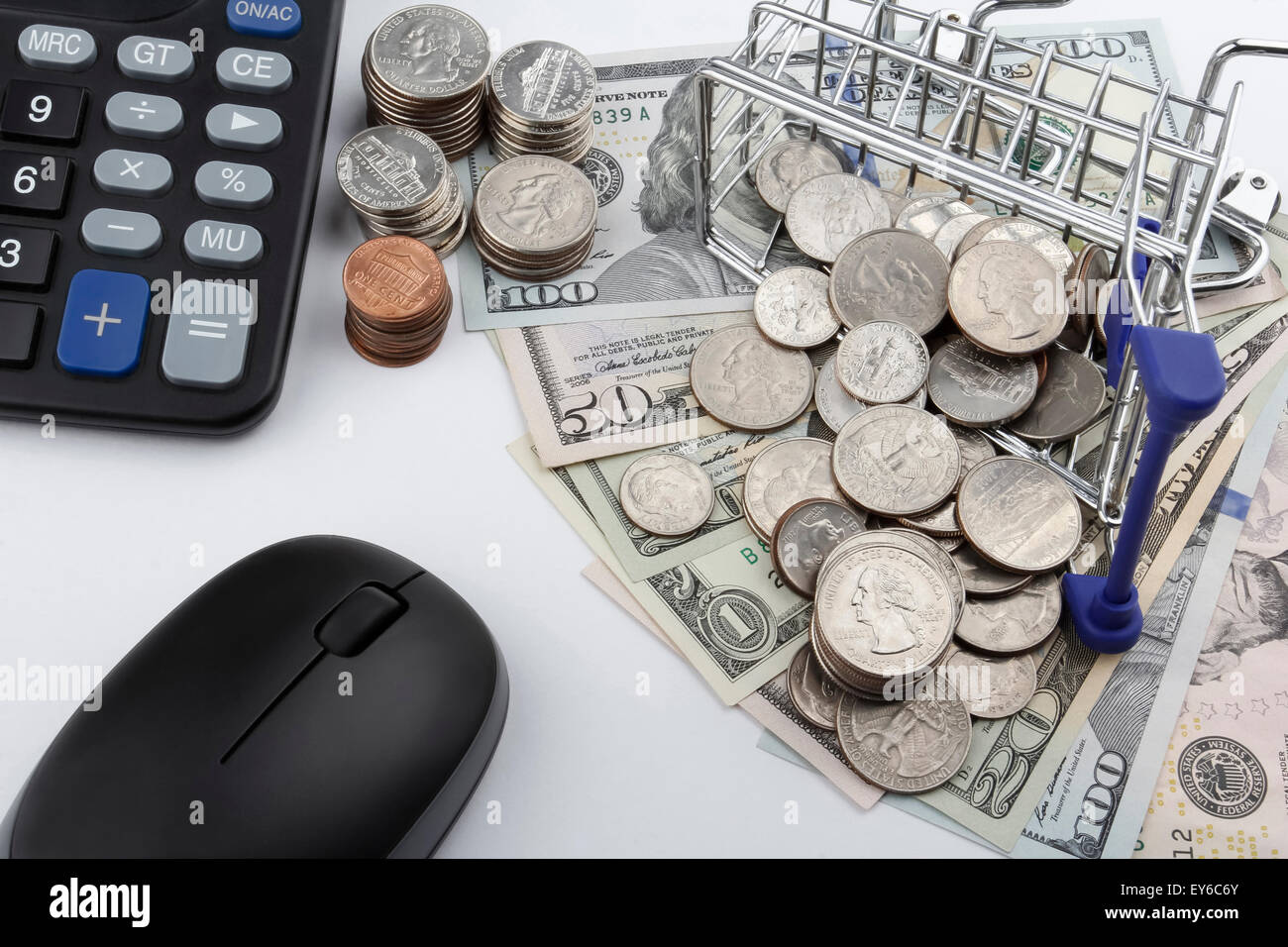 Carrello con monete, banconote, (US Dollari) calcolatrice e un mouse. Foto Stock