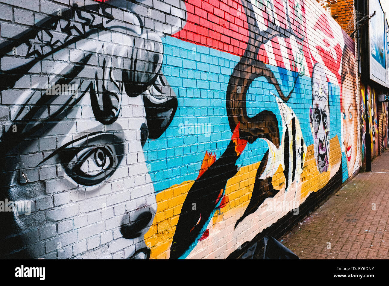 Arte dei graffiti su un muro a Sunderland, UK raffigura l'occhio destro e parte della faccia passare una donna con altri oggetti nel telaio. Foto Stock