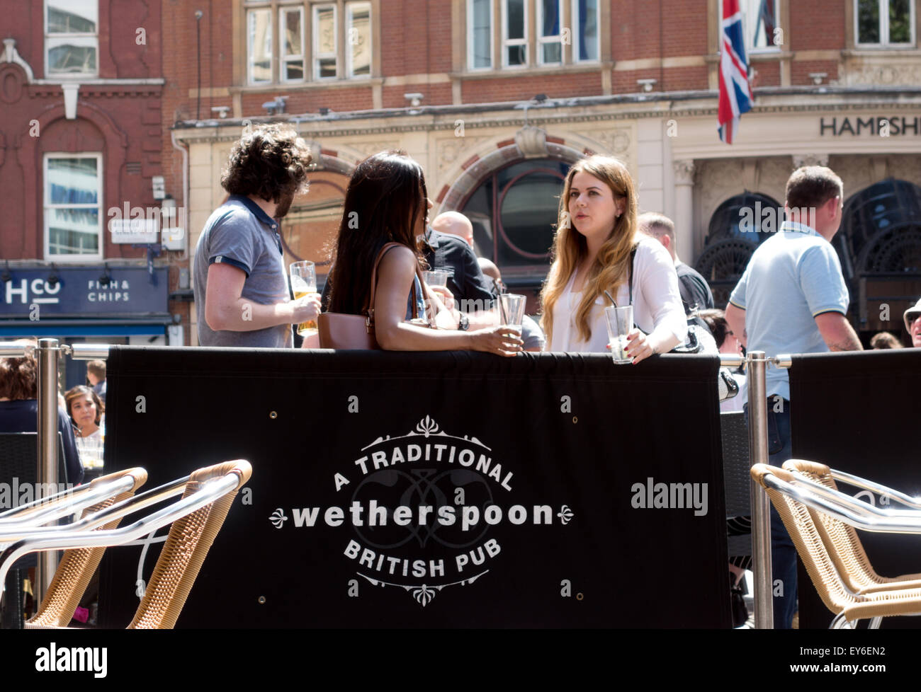 London pub; persone che bevono al Moon sotto l'acqua, un Wetherspoons Pub, Leicester Square, Londra, Regno Unito Foto Stock