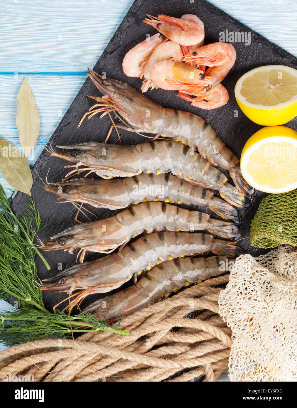 Crudo fresco gamberoni e attrezzature per la pesca sul tavolo di legno Foto Stock