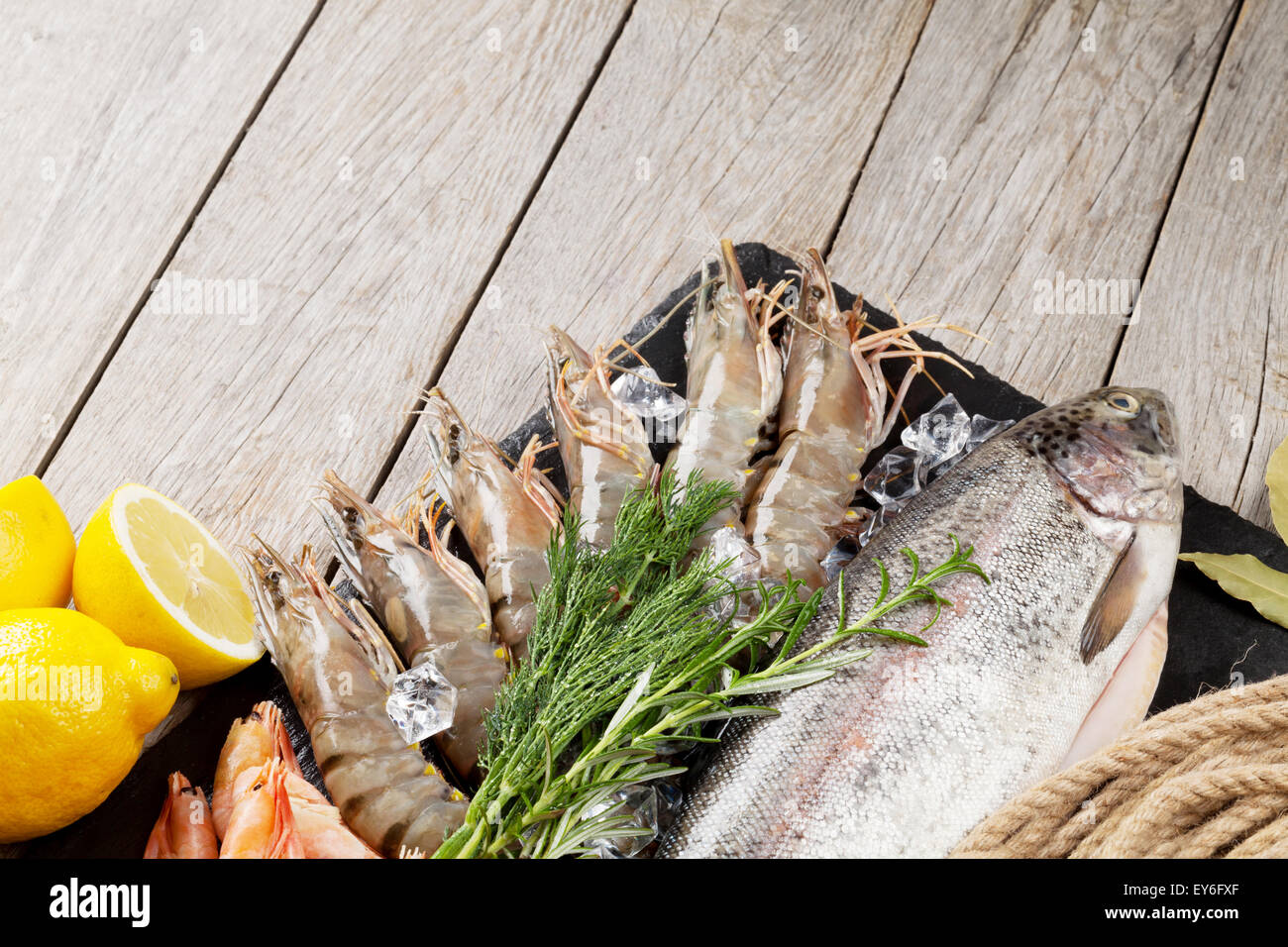 Crudo fresco il cibo del mare con spezie sulla lastra di pietra su un tavolo di legno dello sfondo. Vista superiore Foto Stock