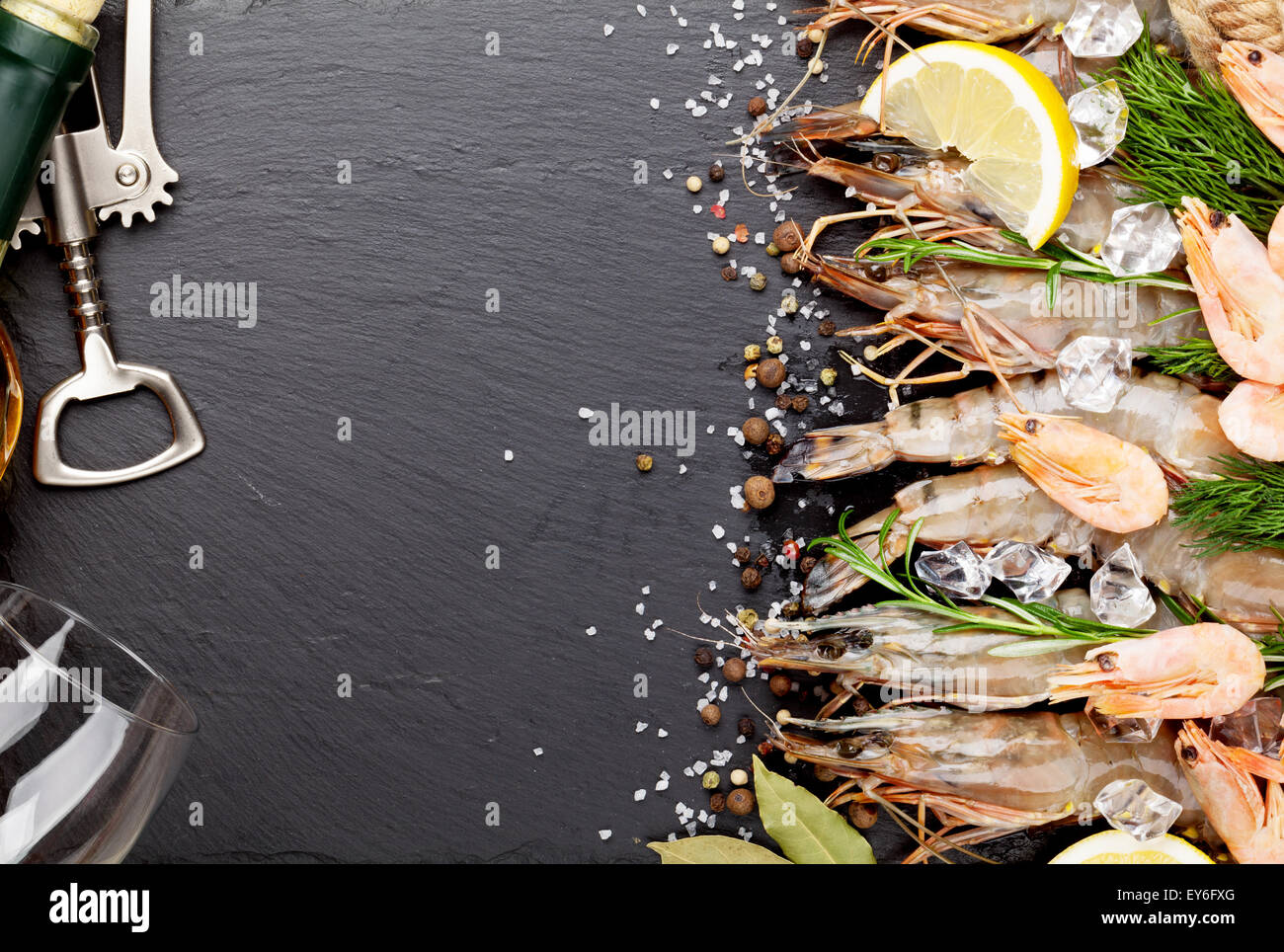 Gamberetti freschi con spezie e vino bianco su nero lo sfondo di pietra. Vista da sopra con lo spazio di copia Foto Stock
