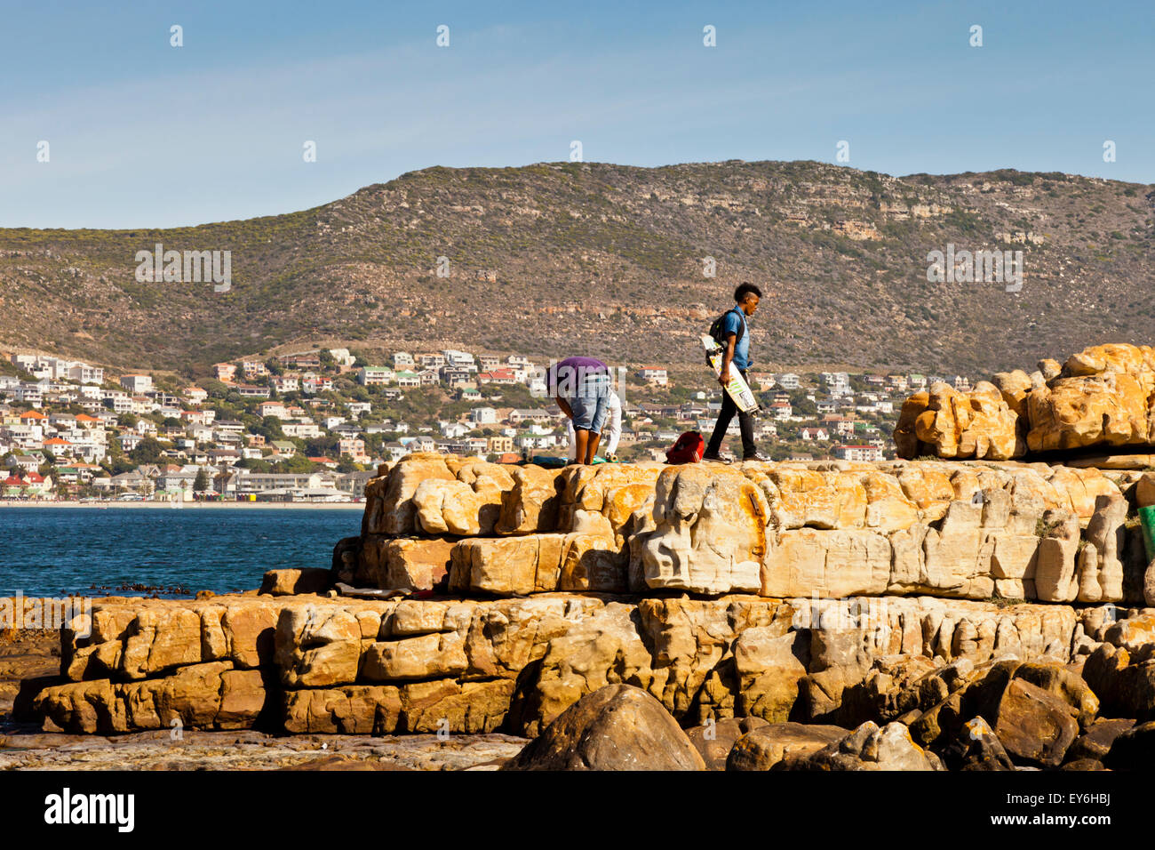 Ragazzi sulle rocce sulla riva di False Bay nei pressi di Kalk Bay e Sud Africa Foto Stock