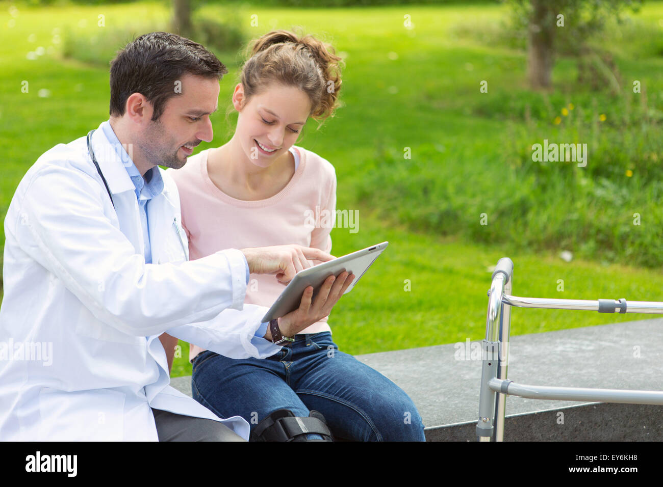 Vista di un medico che mostra la rieducazione suggerimenti su tablet Foto Stock