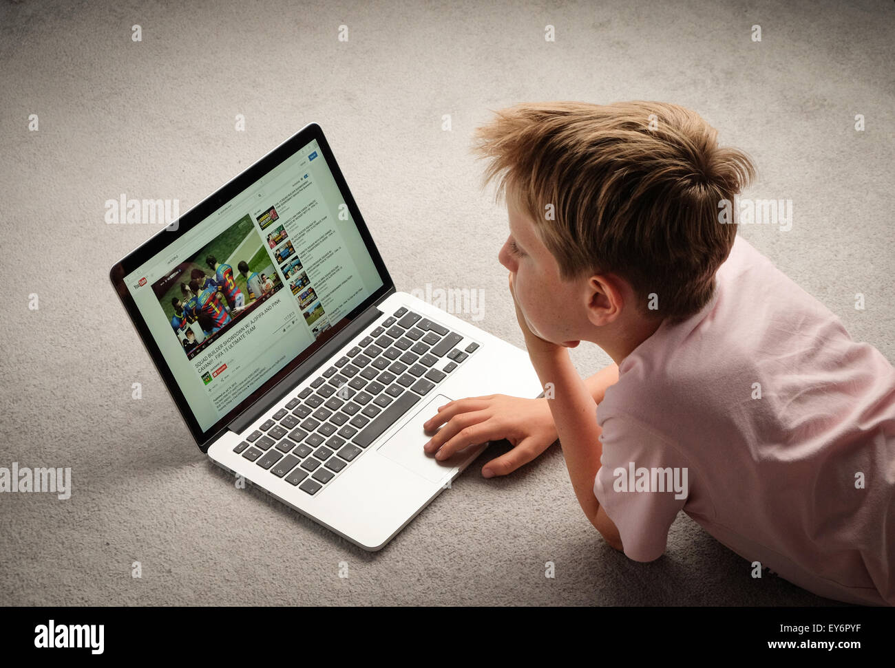 Un bambino guardando i video di Youtube su un computer portatile Foto Stock