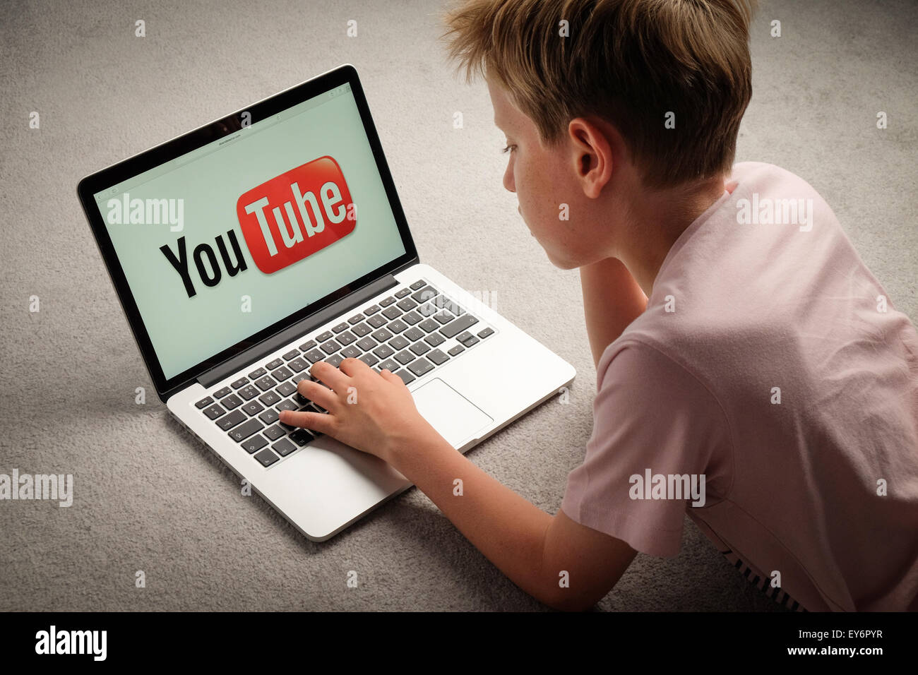 Un bambino guardando i video di Youtube su un computer portatile Foto Stock