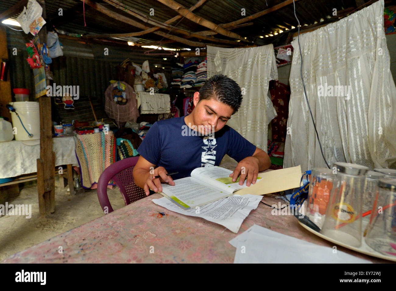 Adolescente, 17 anni, svolgendo compiti nella sua capanna, baraccopoli Colonia Monsenor Romero, Distrito Itália, San Salvador El Salvador Foto Stock