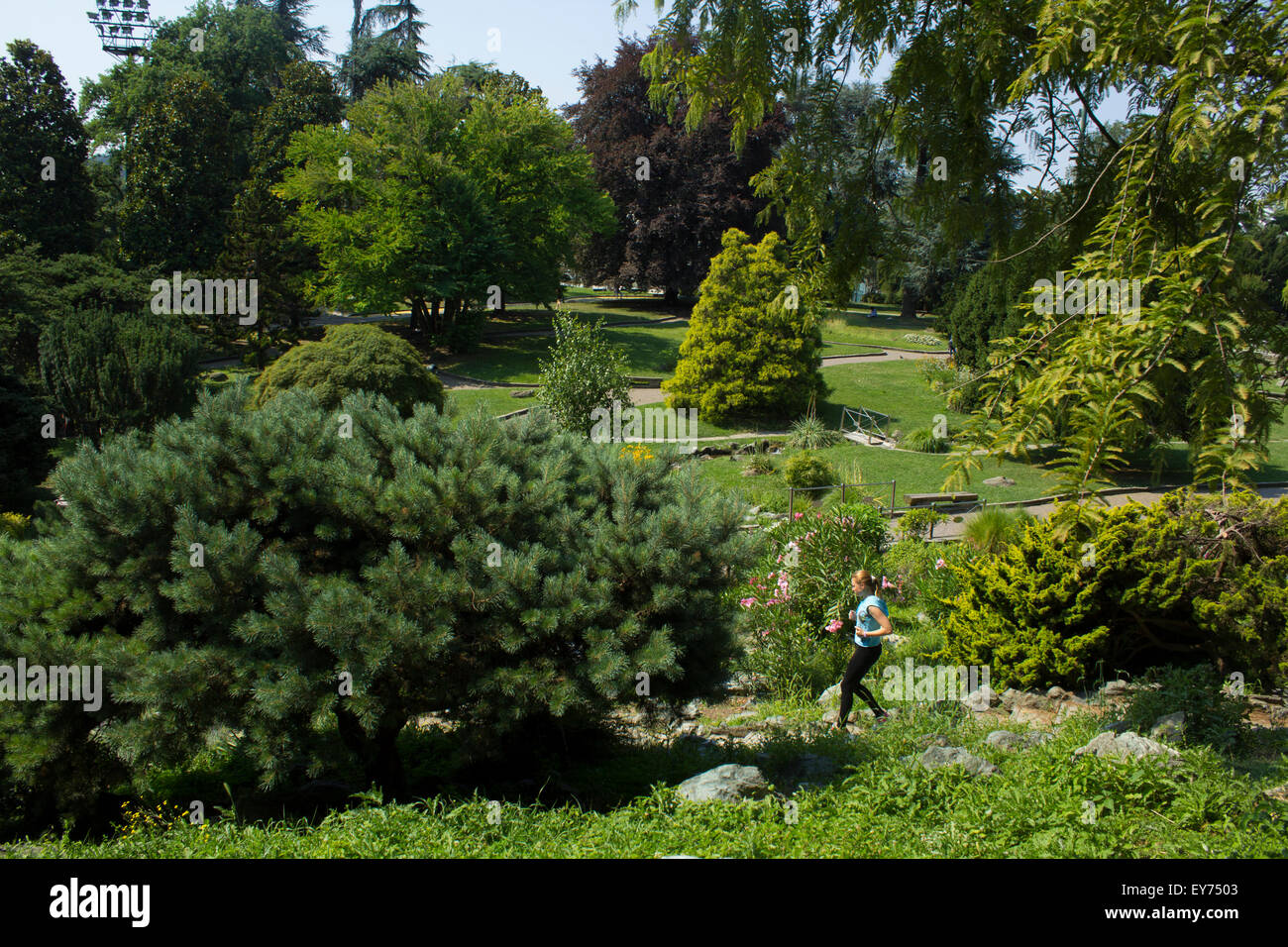 Ragazza bionda in esecuzione presso il parco in estate. Giardini rocciosi, Parco del Valentino, Torino, Italia. Foto Stock