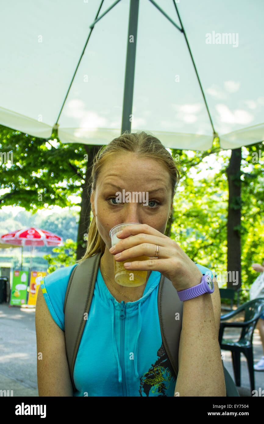 La bionda ragazza russa di bere birra in un parco della città di Torino, Italia. Parco del Valentino, 2015. Foto Stock