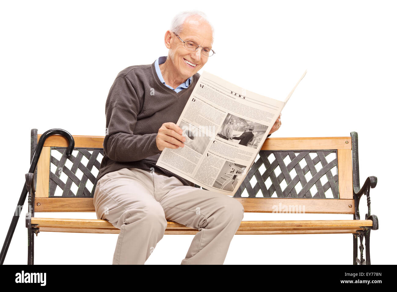 Senior uomo leggendo un giornale seduto su una panca in legno isolato su sfondo bianco Foto Stock
