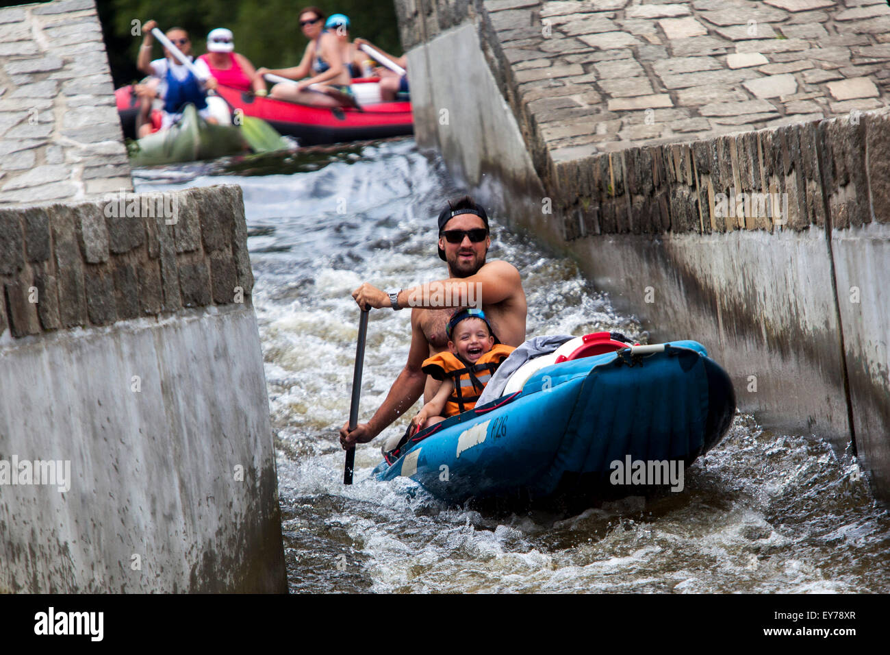 Padre e un figlio che scendono dal fiume Moldava, godendo di rafting, Zlata Koruna weir, Boemia meridionale, Repubblica Ceca Foto Stock