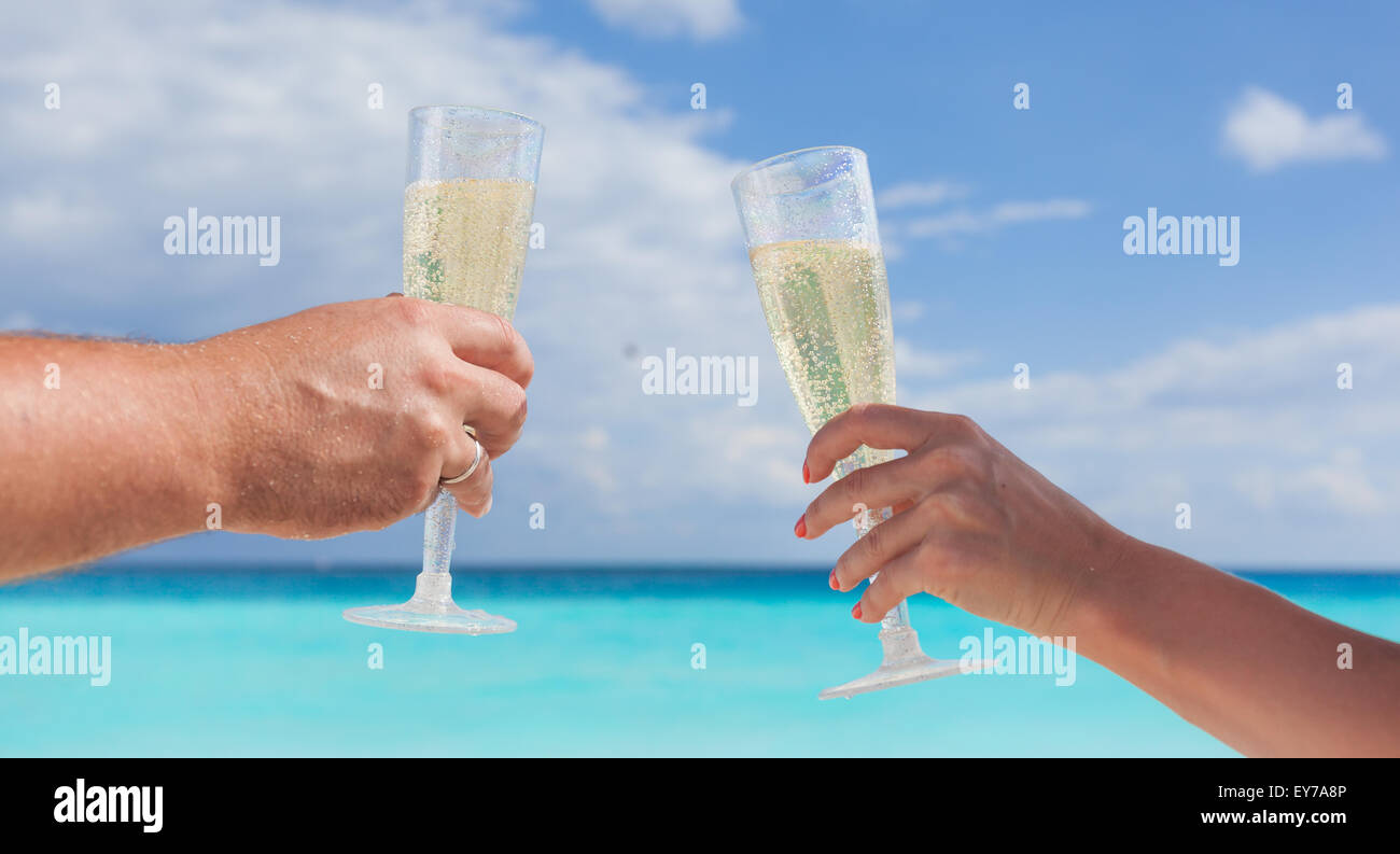 Cembalo che i bicchieri con lo champagne a spiaggia sabbiosa e mare sullo sfondo, profondità minima Foto Stock