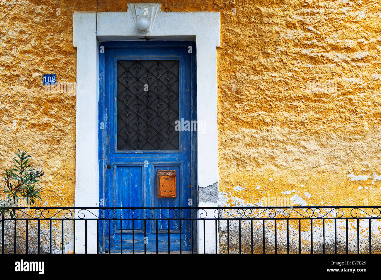 Blu porta anteriore in casa gialla anteriore (Pelion Peninsula, Tessaglia, Grecia). Foto Stock