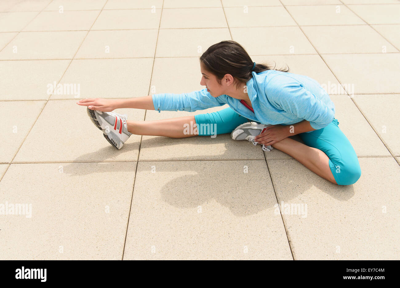 Ragazza adolescente (14-15) stretching Foto Stock