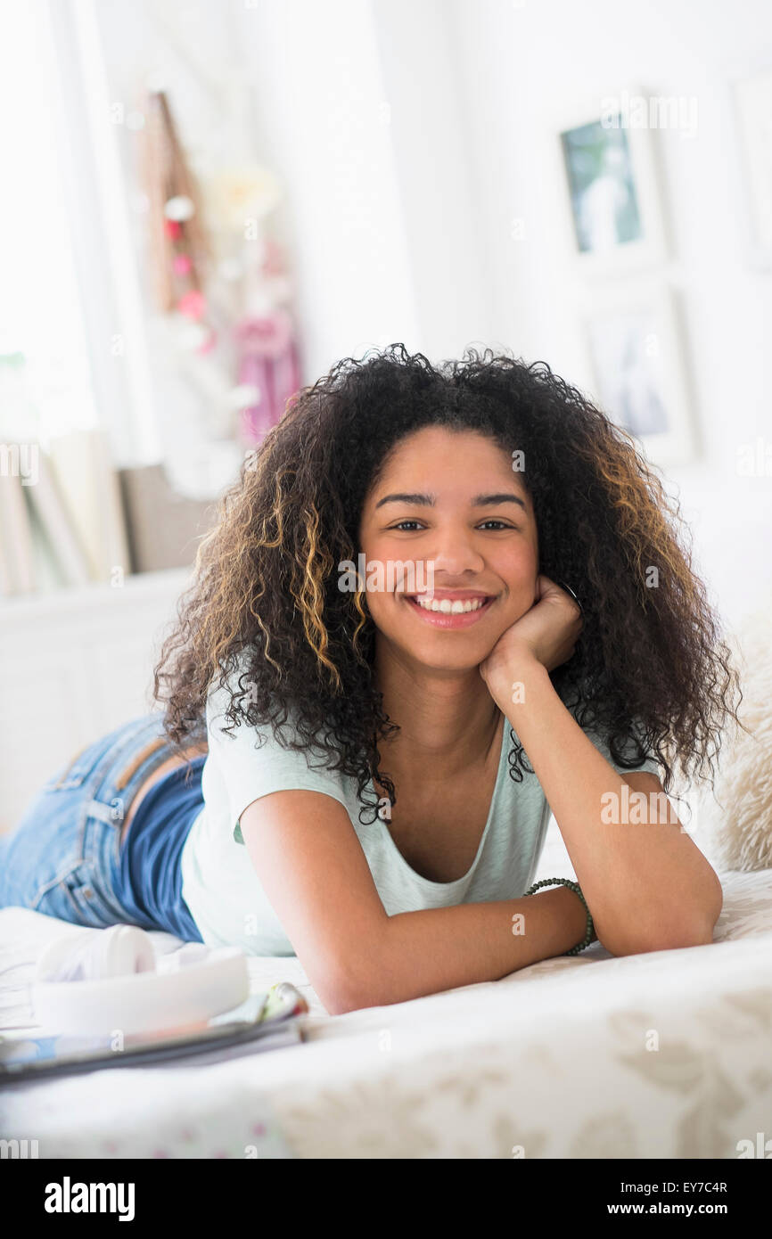 Ritratto di ragazza adolescente (16-17) giacente sul letto Foto Stock
