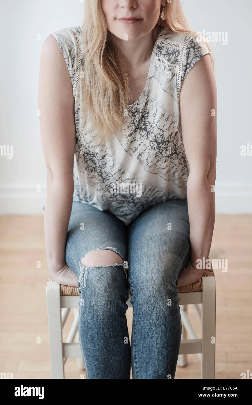 Basso-sezione di donna che indossa jeans strappati Foto Stock