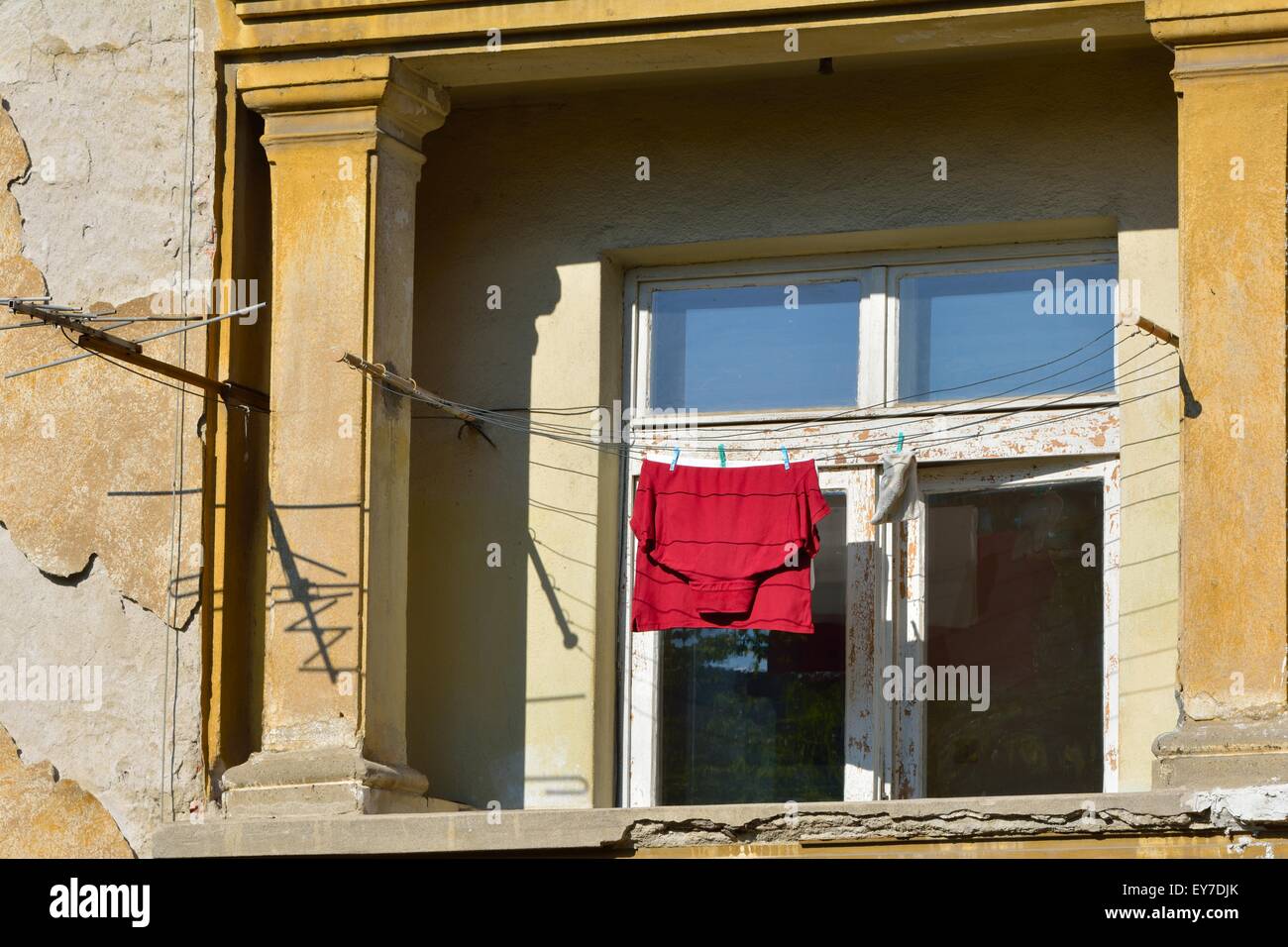 T-shirt rossa appeso sul balcone stendibiancheria ed essiccamento all'aperto Foto Stock
