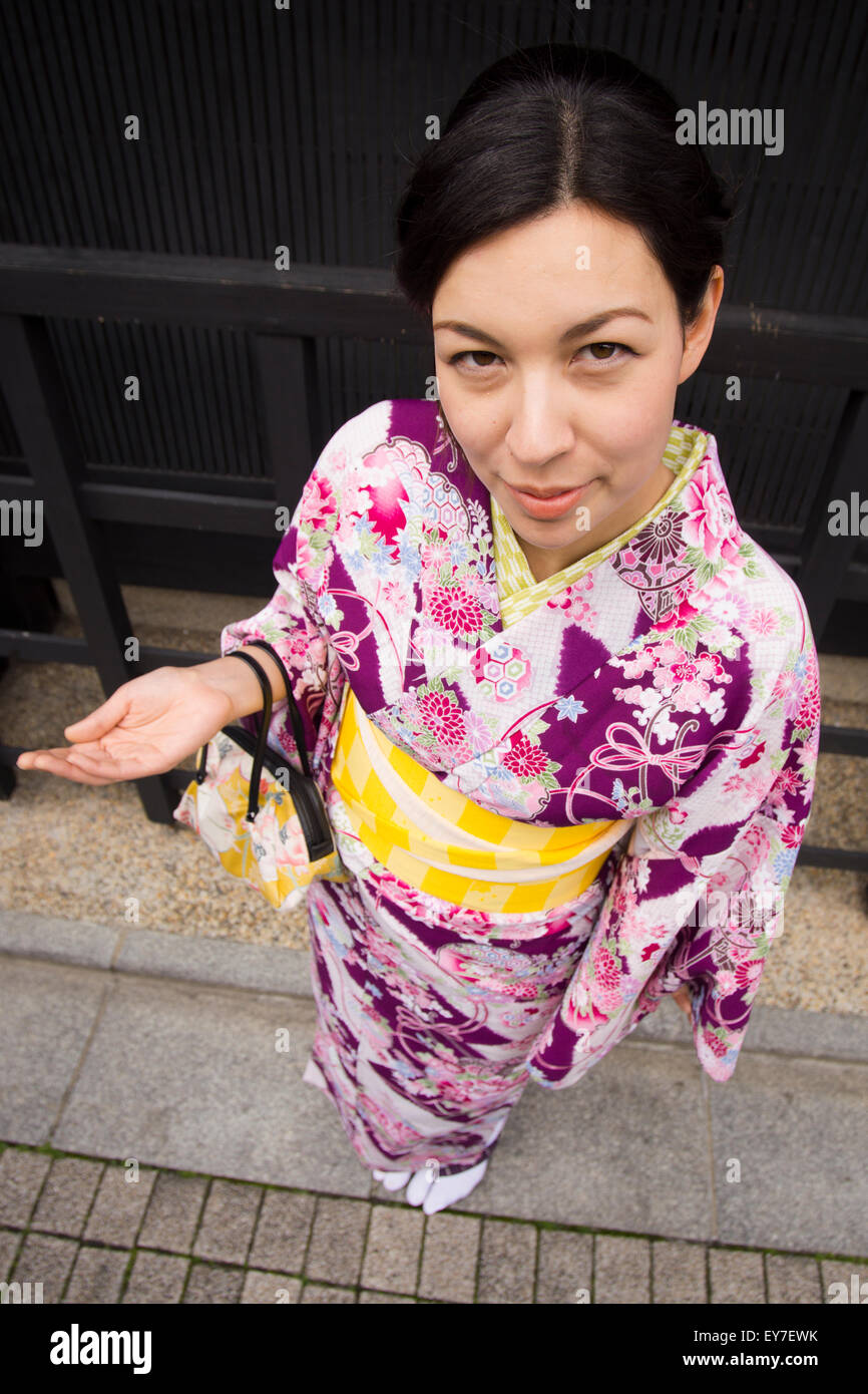 Una giovane donna di noleggiare un kimono, godendo attorno a piedi Gion, Kyoto. Foto Stock