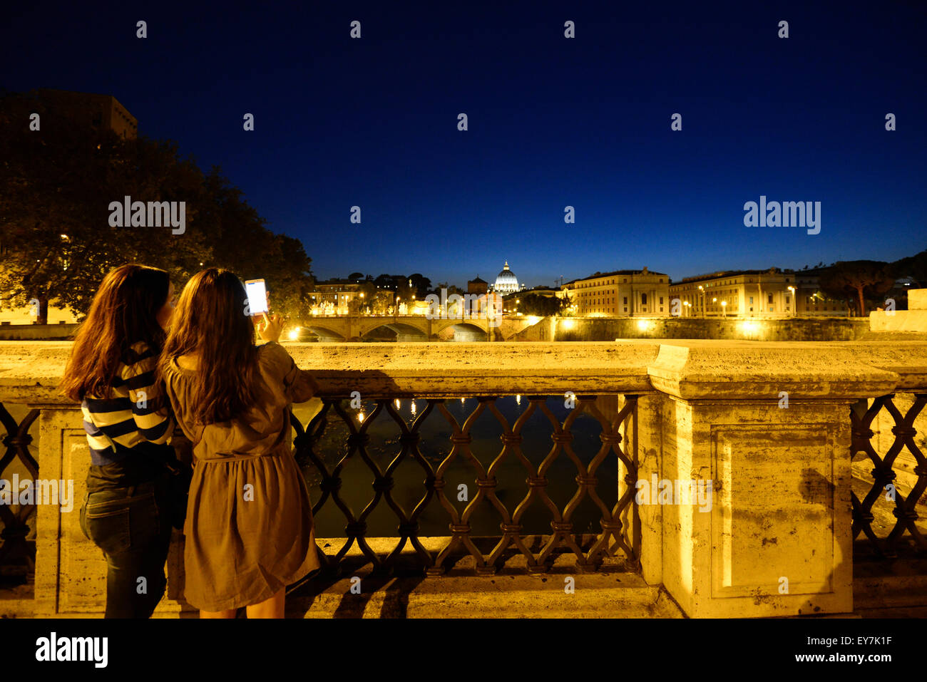 Due ragazze shot una foto a Roma sul Tevere in una notte romantica. Castel Sant'Angelo & San Angel telaio a ponte in questo momento. Foto Stock