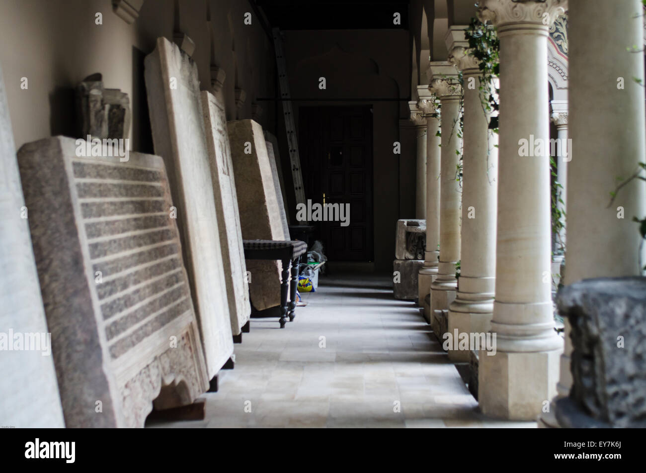 Manufatti in pietra della Chiesa di Bucarest fiancheggiati da un corridoio storico circondato da colonne e ombre ornate Foto Stock