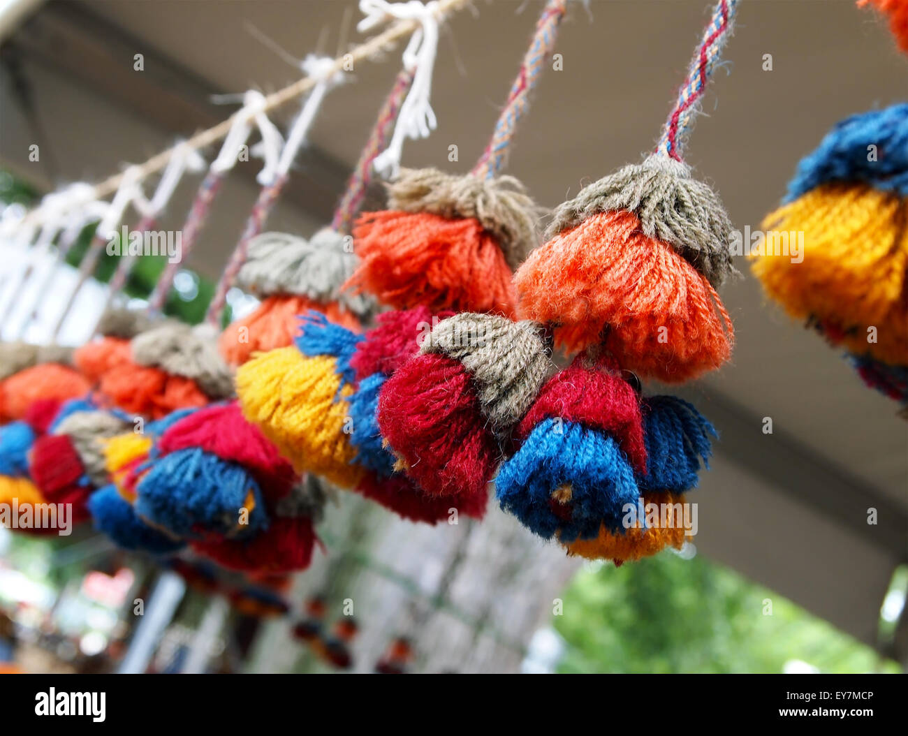 Una fila di vivaci e colorati, multi-layered nappe di fantasia pendente da una corda decorare un festival all'aperto stand. Foto Stock