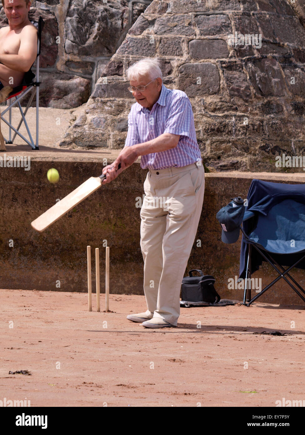 Senior Citizen giocando beach cricket, Goodrington Sands Paignton, Devon, Regno Unito Foto Stock