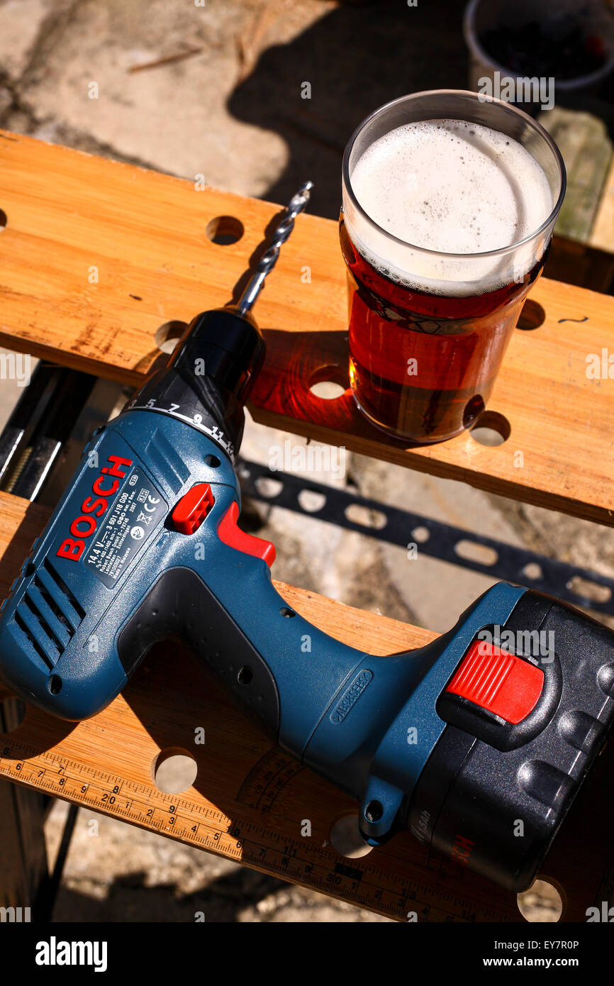 Banco di lavoro e strumenti con una pinta di birra Foto Stock