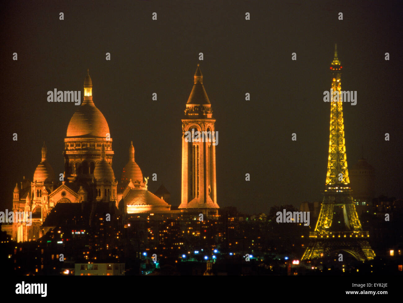 Il Sacro Cuore e la Torre Eiffel al di sopra dello skyline di Parigi di notte Foto Stock