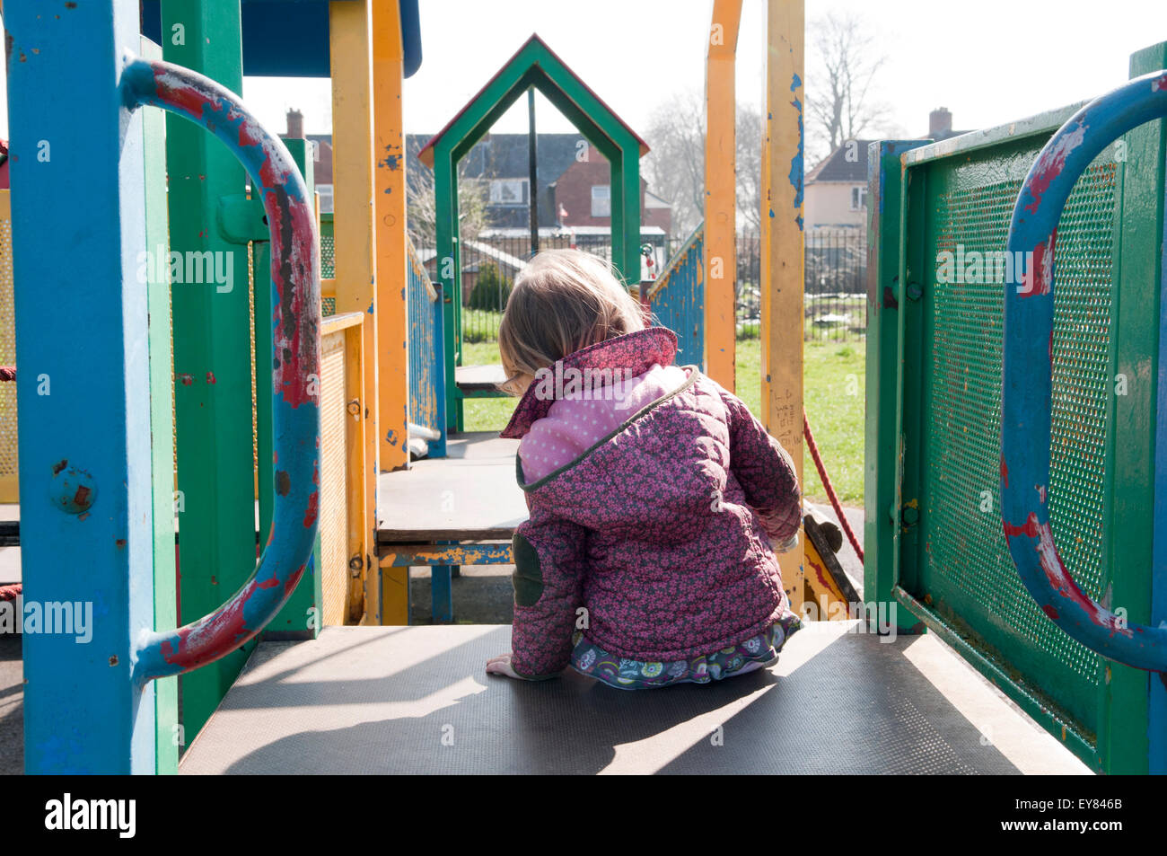 Il Toddler giocando su un telaio di arrampicata nel parco Foto Stock