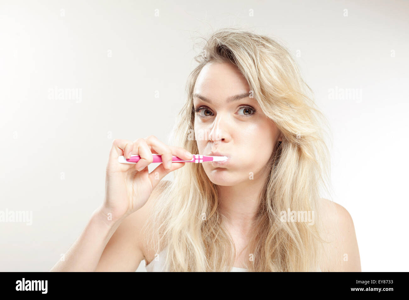 Giovane donna spazzolare i suoi denti Foto Stock
