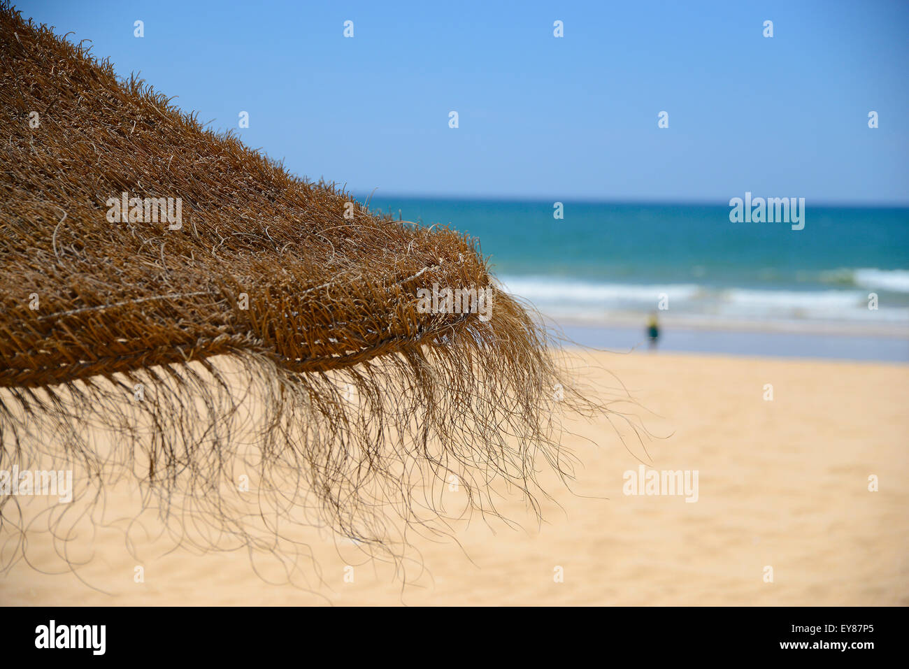 Signora sulla spiaggia di sabbia dorata con cielo blu e blu acqua Foto Stock