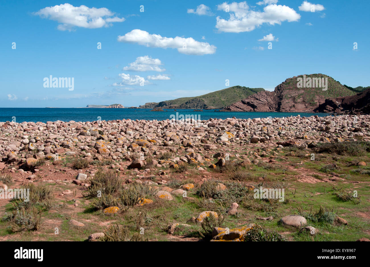 La spiaggia di ciottoli a Macar d'Alfurinet guardando in giù la rocciosa costa nord di Menorca Spagna Foto Stock