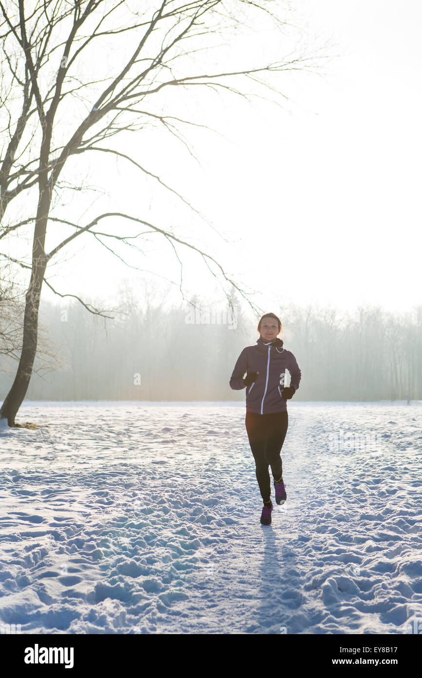 Giovane donna fare jogging nel paesaggio invernale Foto Stock
