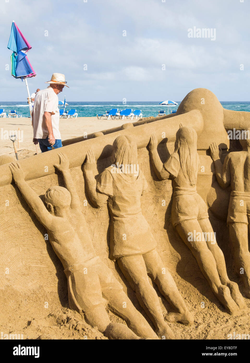 Las Palmas de Gran Canaria, Isole Canarie, Spagna. Il 24 luglio, 2015.scultori di sabbia sul lavoro la scultura di sabbia di bambini spingendo turbina eolica sulla spiaggia di Las Canteras a Las Palmas. La scultura è parte di Greenpeace Spagna le energie rinnovabili campaing/giornata di sensibilizzazione sulla spiaggia sabato 25 luglio. Credito: ALANDAWSONPHOTOGRAPHY/Alamy Live News Foto Stock