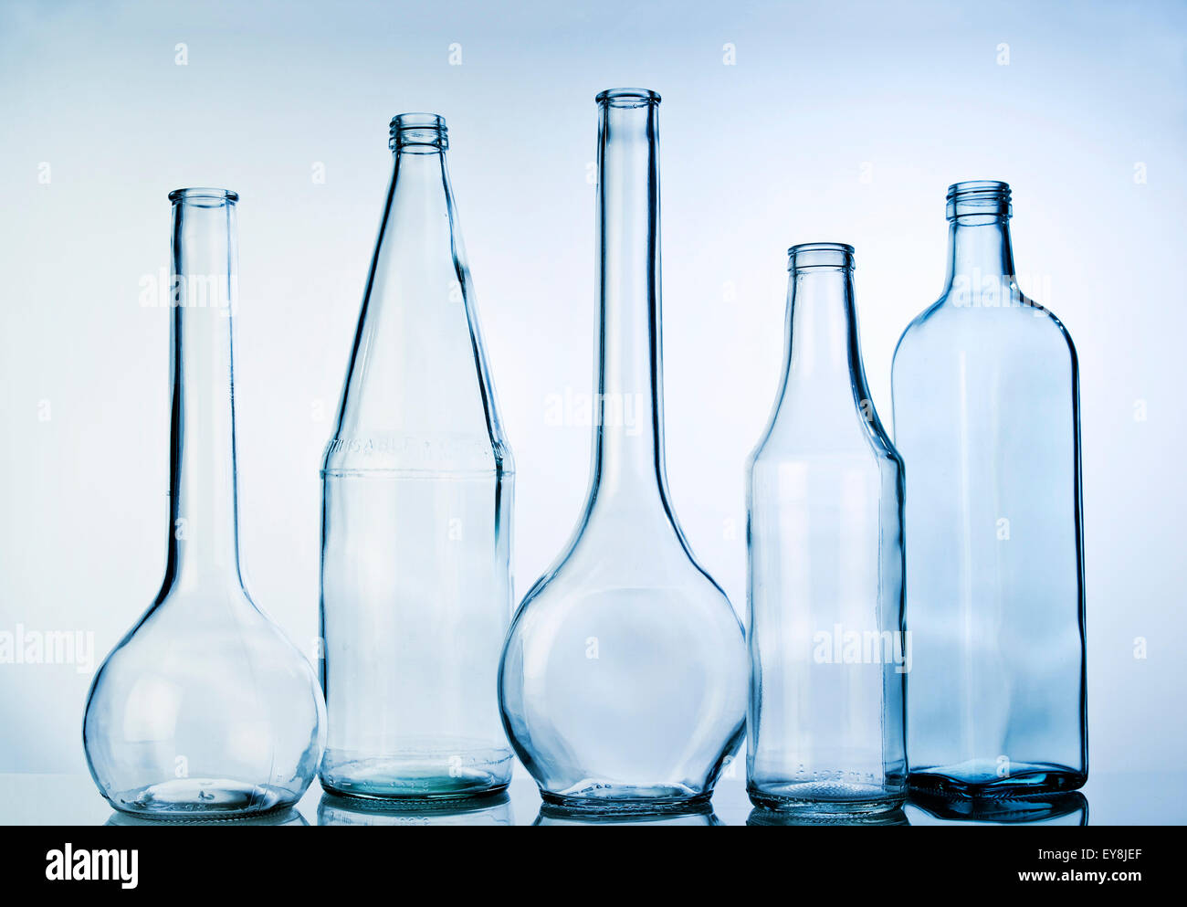 Cinque bottiglie di vetro in una riga Foto Stock