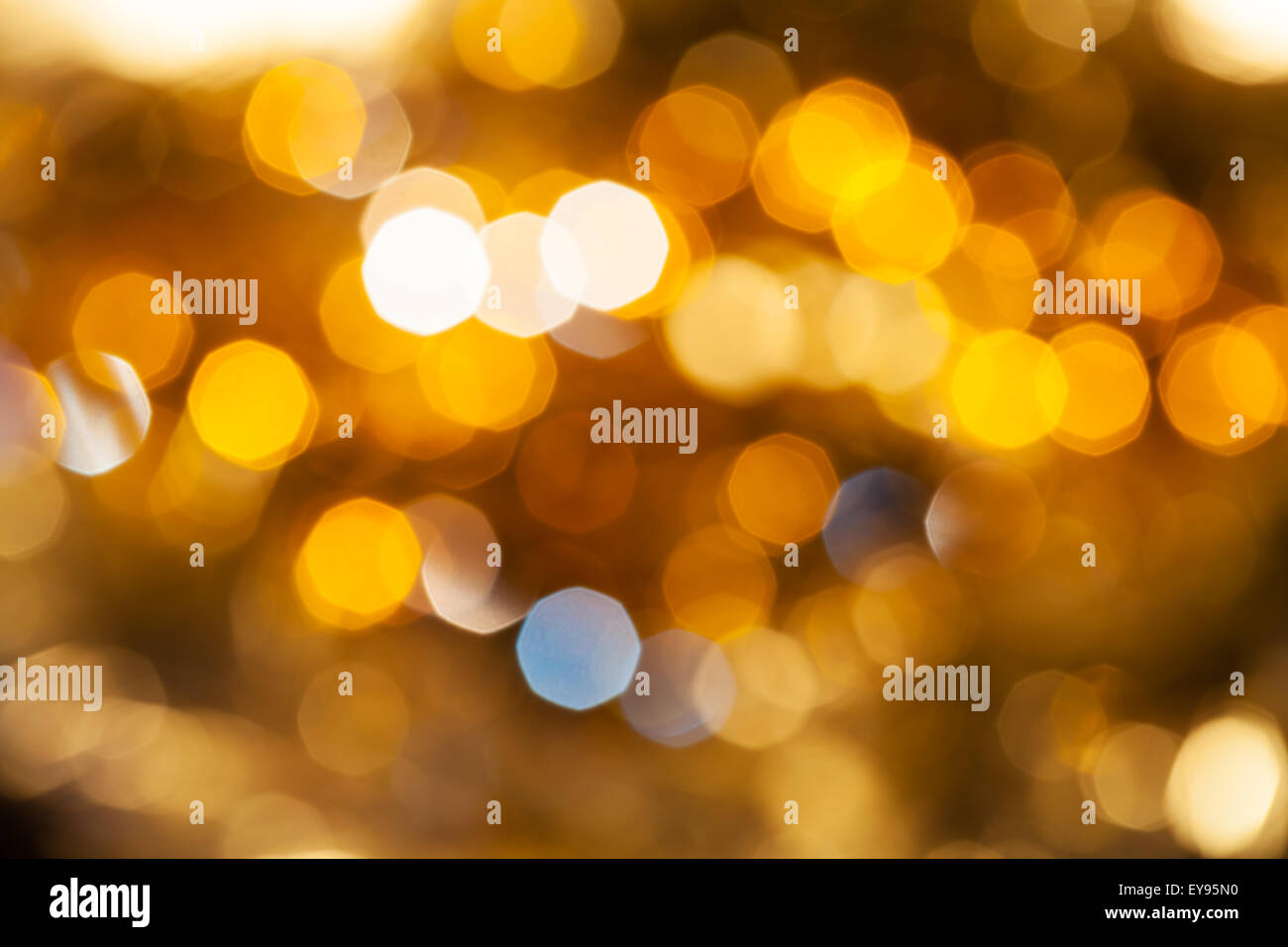 Abstract sfondo sfocato - giallo e marrone e scintillanti luci di Natale di le ghirlande elettriche su albero di Natale Foto Stock