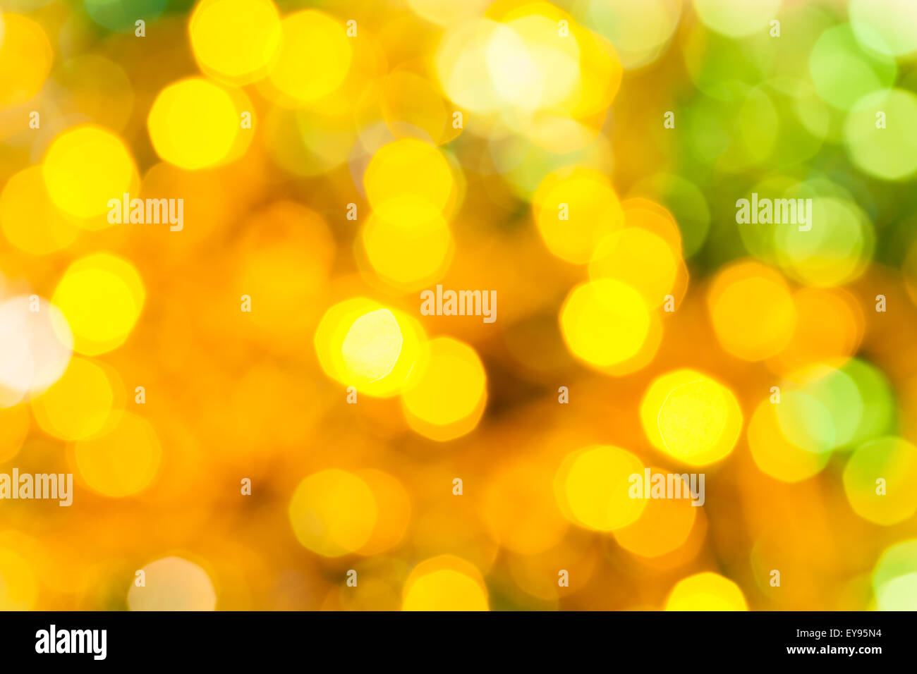 Abstract sfondo sfocato - giallo e verde scintillanti luci di Natale di le ghirlande elettriche su albero di Natale Foto Stock