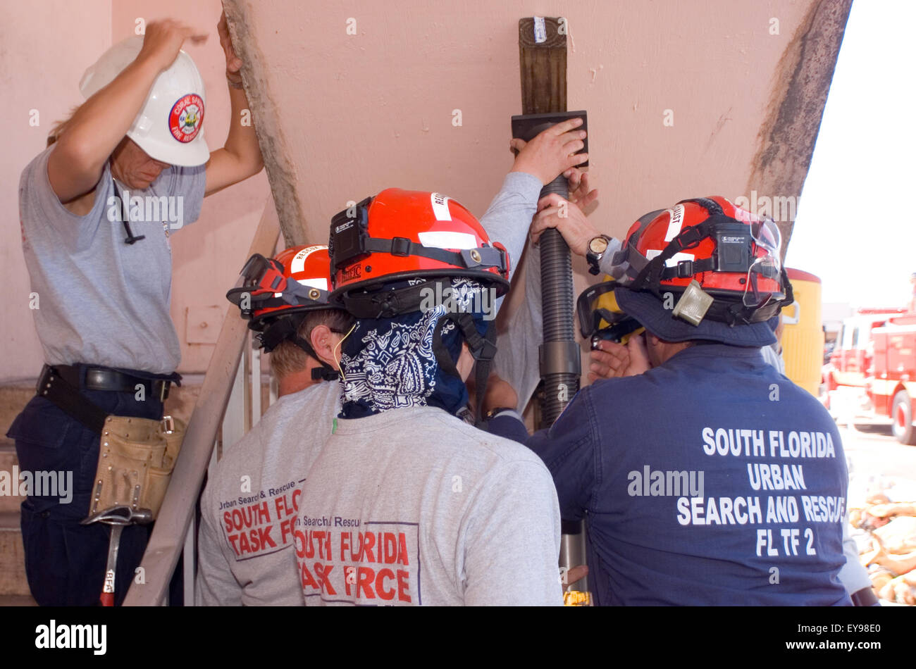 I membri di una ricerca e salvataggio in aree urbane di team di treno mediante il supporto di un muro contro il crollo in una situazione simulata. Foto Stock