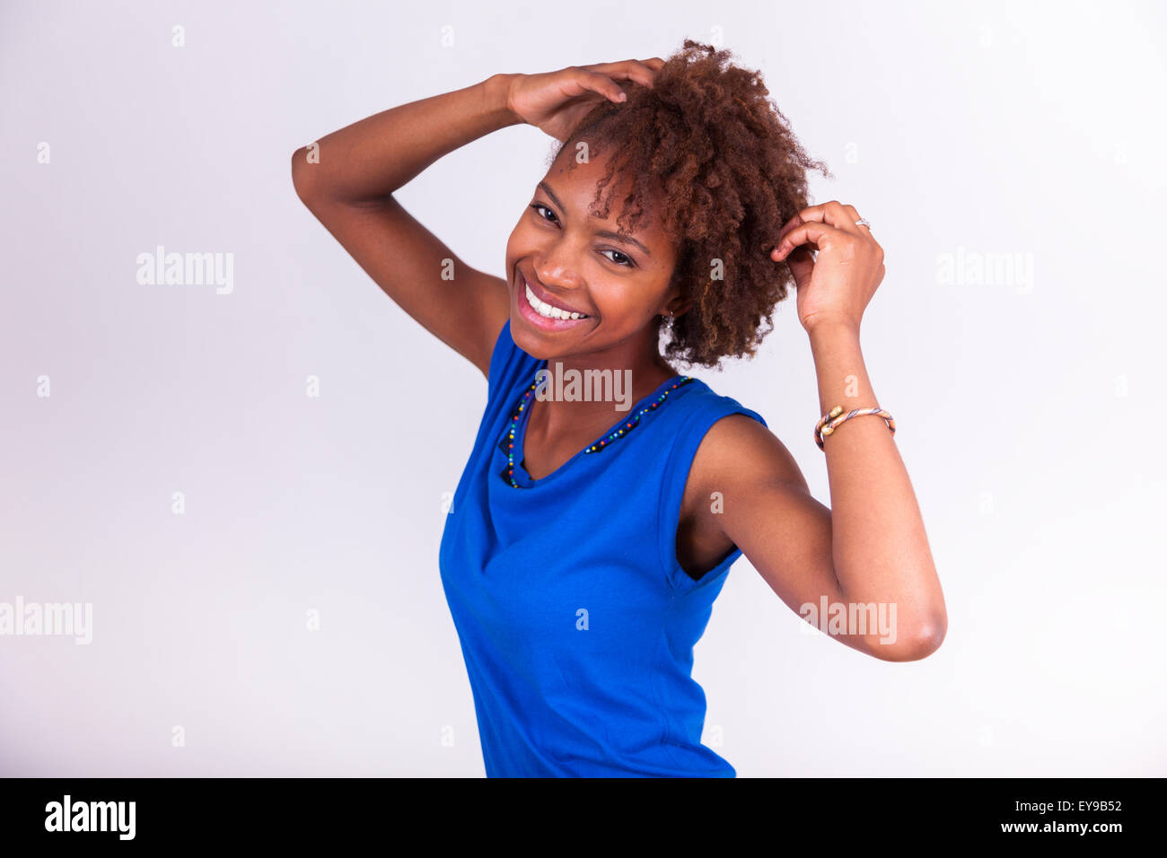 Giovane africano donna americana tenendo le sue frizzy capelli afro - gente nera Foto Stock