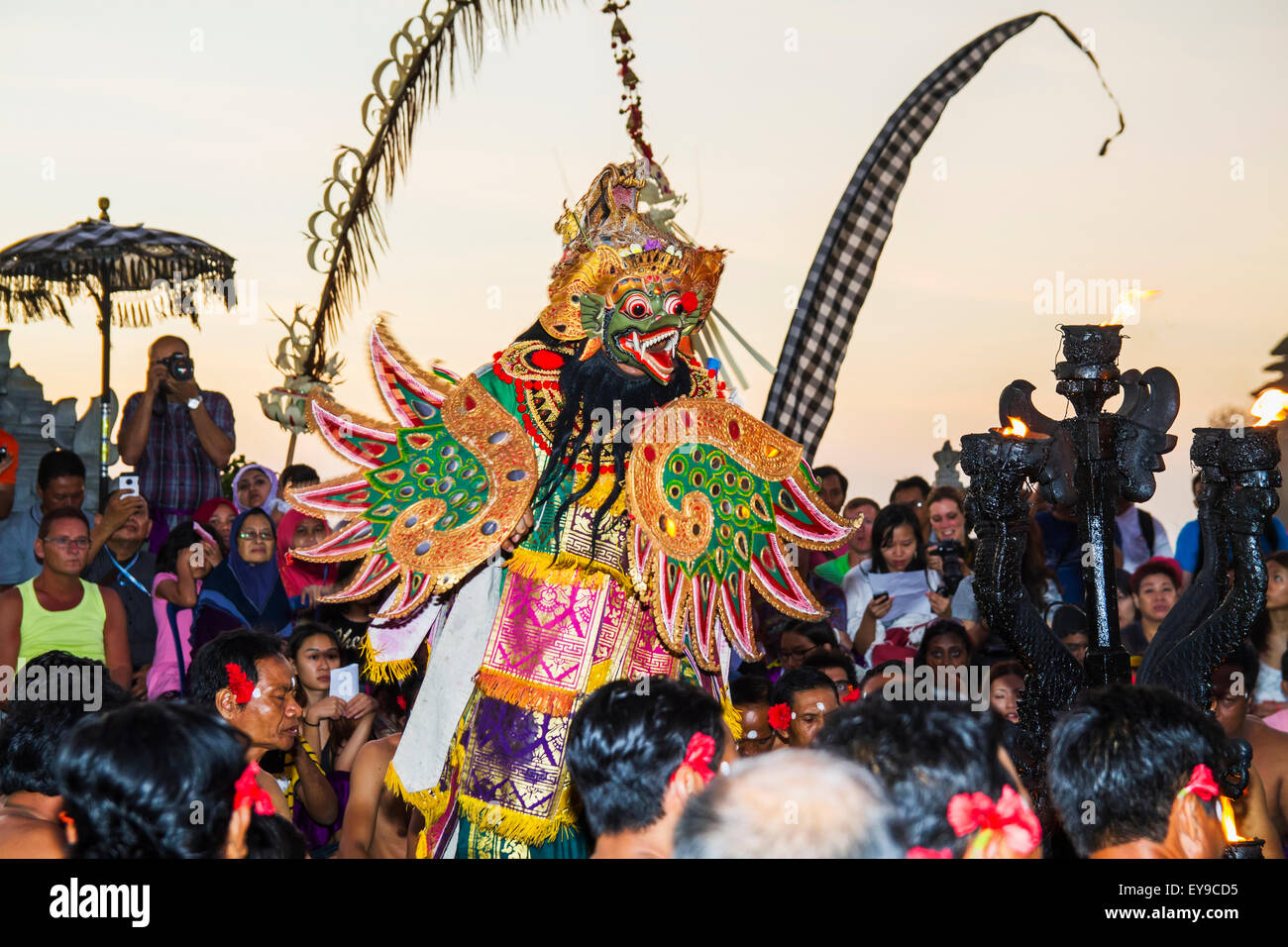 Garuda circondato da uomini seduti in cerchio cantando in trance durante una danza Kecak prestazioni, Ulu Watu, Bali, Indonesia Foto Stock