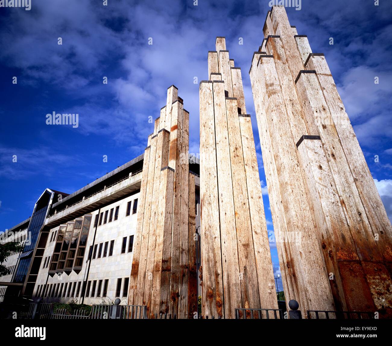 Basso angolo vista della scultura del giunto di colonne di basalto simili accanto a un edificio, Derry, County Londonderry, Irlanda del Nord Foto Stock
