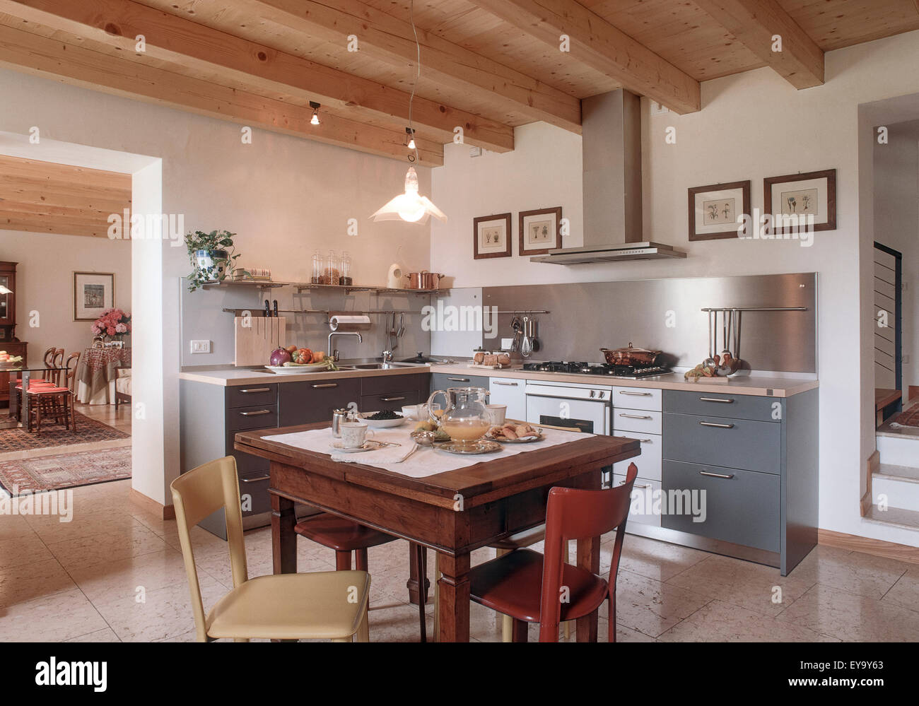 Primo piano della tabella prevista in una cucina rustica con pavimento in marmo e soffitto in legno Foto Stock
