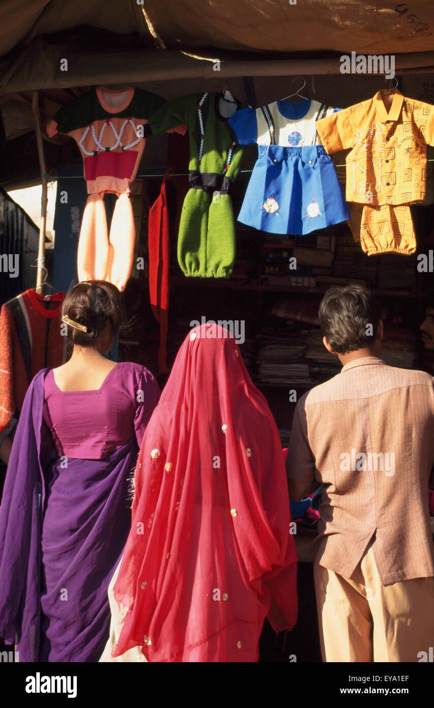 Le persone in cerca di abbigliamento per bambini in stallo,Chirawa,Shekhawati,Rajasthan,l'India. Foto Stock