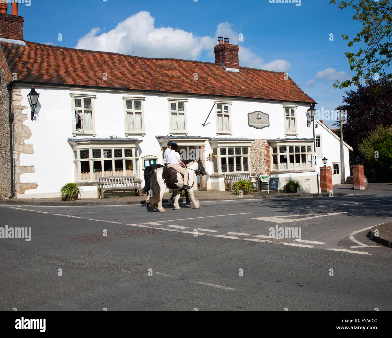 Due persone a cavallo del villaggio di Ramsbury, Wiltshire, Inghilterra, Regno Unito Foto Stock