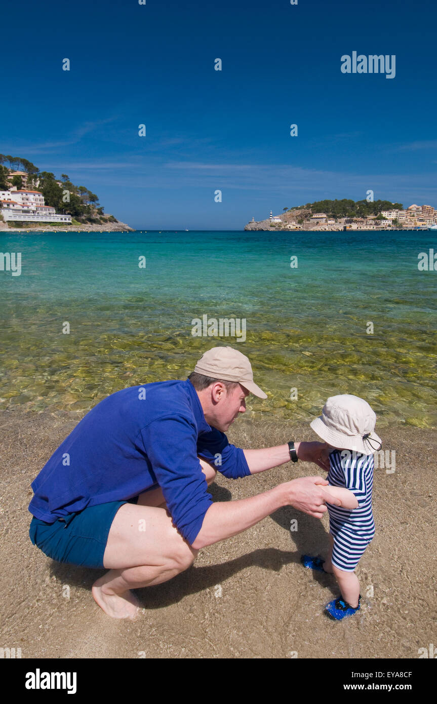 Padre Holding Baby Boy (6-11 mesi) da mani sulla spiaggia, Soller,Mallorca,Isole Baleari,Spagna Foto Stock