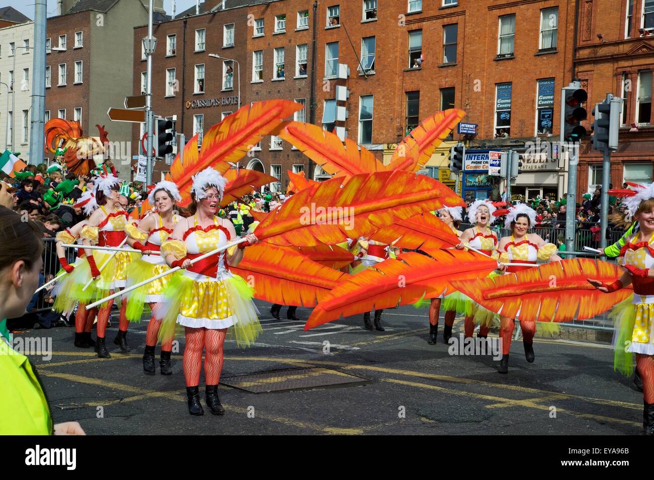 Dublino, Irlanda; donne in costume di danza con grandi piume come parte di una sfilata su O'Connell Street Foto Stock