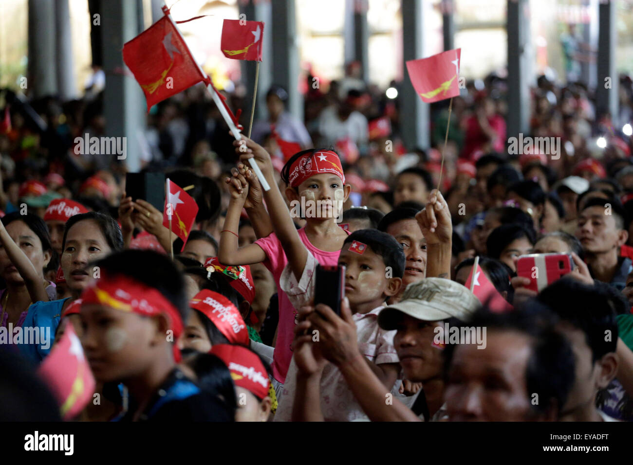 Kyitelatt, Kyitelatt township di Ayeyarwady Regione del Myanmar. Xxv Luglio, 2015. Persone tengono le bandiere della Lega nazionale per la democrazia (NLD) in attesa di ascoltare un discorso di Aung San Suu Kyi, leader del Myanmar la NLD, durante una educazione degli elettori campagna presso Kyitelatt township di Ayeyarwady Regione del Myanmar, il 25 luglio 2015. Credito: U Aung/Xinhua/Alamy Live News Foto Stock