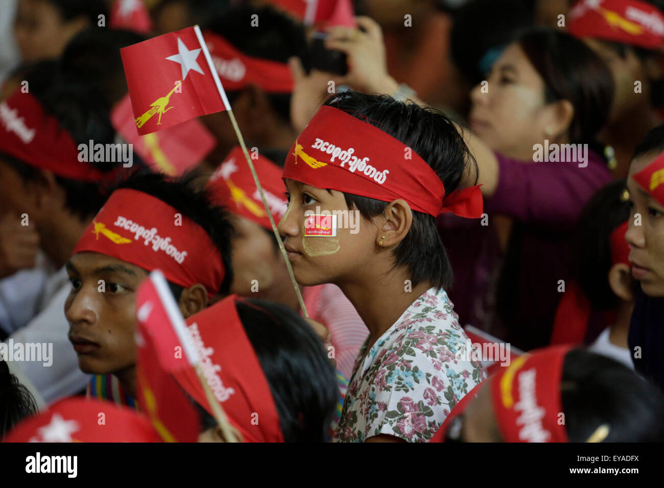 Kyitelatt, Kyitelatt township di Ayeyarwady Regione del Myanmar. Xxv Luglio, 2015. Una ragazza tiene una bandiera della Lega nazionale per la democrazia (NLD) come lei attende di ascoltare un discorso di Aung San Suu Kyi, leader del Myanmar la NLD, durante una educazione degli elettori campagna presso Kyitelatt township di Ayeyarwady Regione del Myanmar, il 25 luglio 2015. Credito: U Aung/Xinhua/Alamy Live News Foto Stock