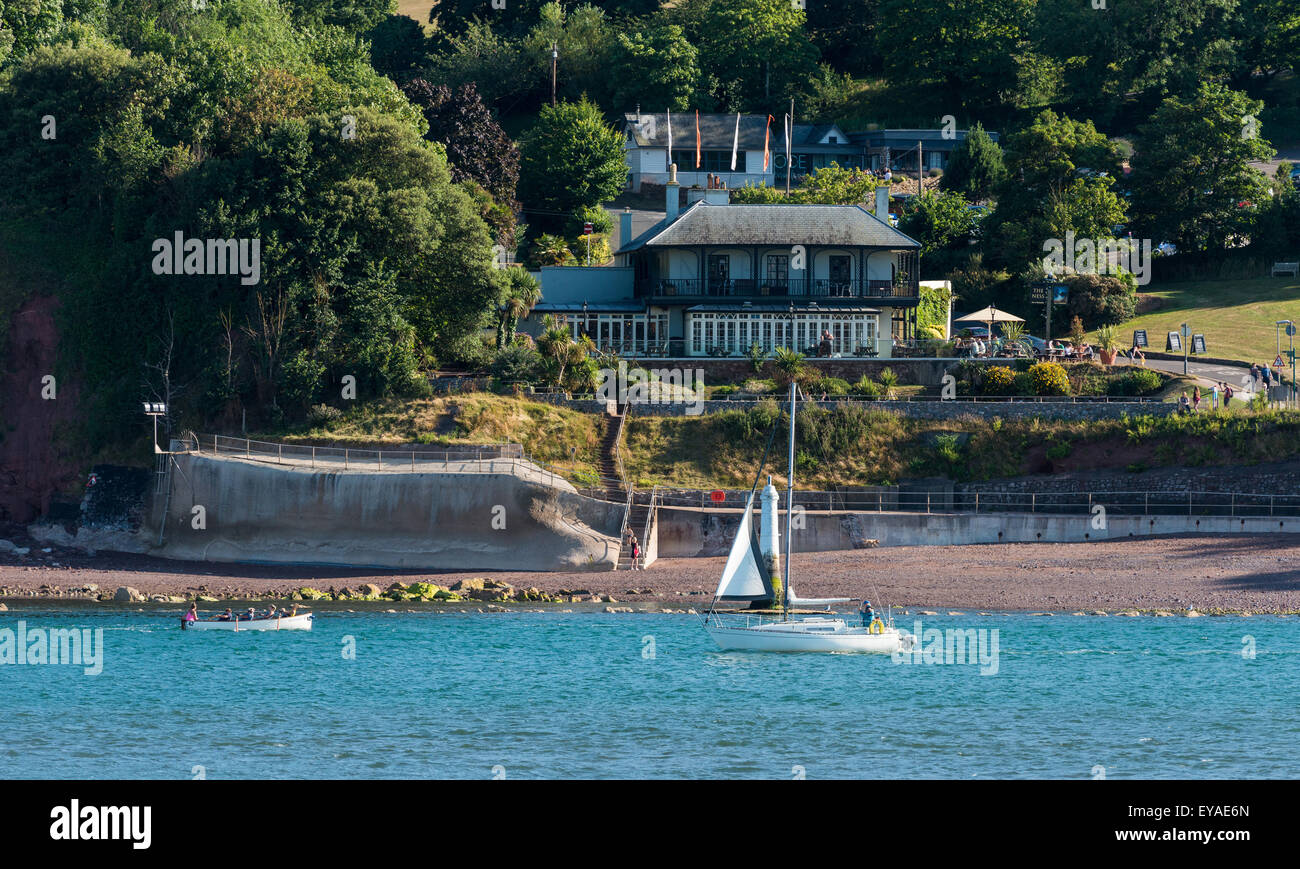 Una barca lascia il fiume Teign nel Devon per il mare aperto come una femmina di equipaggio barca a remi un gig entrare nella foce del fiume dal mare. Foto Stock